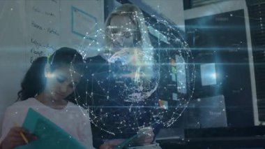 Öğretmen deniz mavisi çalışma kitabını gösteriyor ve sınıftaki holografik kürenin altında yazan öğrencilere rehberlik ediyor. Eğitim, akıl hocalığı, teknoloji, yenilik, işbirliği, dijital, öğrenim