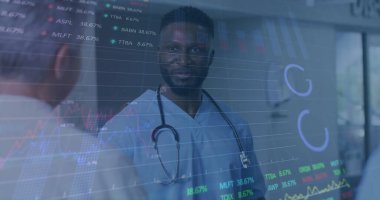 Ameliyat önlüğü ve steteskop uzmanı. Tabloları analiz ediyor. Hastane koridorunda saatleri sergiliyor. Tıbbi, teknoloji, işbirliği, sağlık, veri, analiz, yenilik