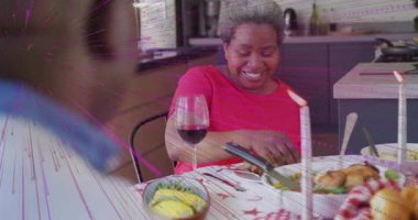 Kadın salata ve tavuk hazırlıyor, yaşlı adama şarap kadehi kaldırıyor ve evde yemek yiyor. Aile, kutlama, neşe, sıcaklık, zarafet, birliktelik, gündelik.