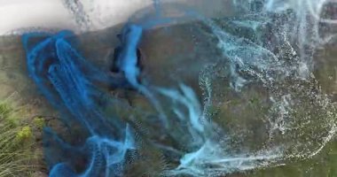 Tabletten güç alan ve tepenin etrafındaki mavi-beyaz kurdeleleri haritalandırmak için şekillendiren bir adam. Gelecek, keşif, yenilik, teknoloji, doğa, veri görselleştirme, açık hava