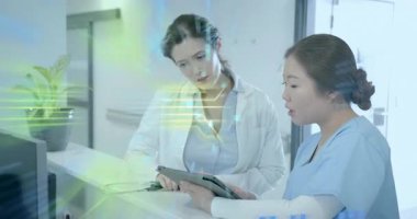 Hemşire ve doktor tableti tıkırdatıyor ve hasta kayıtlarını yükleme işlemini başlatıyorlar. Tıbbi teknoloji, dijital sağlık, sağlık sektörü, teletıp, klinik veriler, fütüristik, hastane ortamı