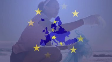 Gönüllü olarak plajı temizlerken bayrağın canlandırılması. Küresel vatanseverlik ve dijital arayüz kavramı dijital olarak oluşturulmuş video.