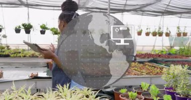 Sera işçisi tablet tıklayarak bitki verilerini inceliyor şeffaf dünya animasyon simgelerini başlatıyor. Bahçecilik, teknoloji, sürdürülebilirlik, tarım, yenilik, takım çalışması, çevre dostu