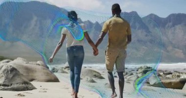 Sahili keşfederken teknoloji dalgaları arasında kayaların arasında el ele tutuşan çift. Romantik, macera, dinginlik, kıyı şeridi, keşif, sükunet, doğa