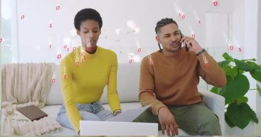 Man lifting smartphone initiating call while woman reviewing paper typing laptop amid binary code. Collaboration, digital, technology, workspace, communication, contemporary, innovation