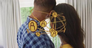 Kadın ve erkek pencerelerden kafalarına dokunuyor, ikonlar etrafında dönerek teknolojik bağlantıyı gösteriyor. Yakınlık, bağlantı, teknoloji, ağ, dijital, uyum, iletişim