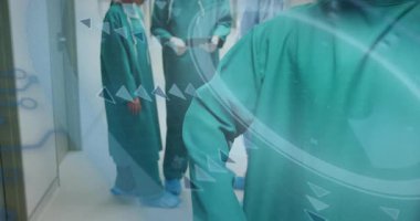 Yukarıya doğru bakan cerrahlar, tabletteki hasta verilerini üçgenler halinde tarayan koridorları inceliyor. Tıbbi, takım çalışması, profesyonel, sağlık hizmetleri, işbirliği, klinik, modern