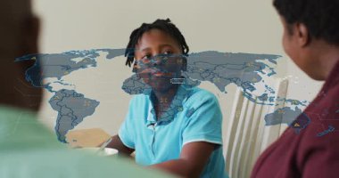 Kahvaltıda mısır gevreğinin üzerine kaşık kaldıran bir çocuk dünya haritası teknolojisi şebekesinin büyüdüğünü söylüyor. Aile, kahvaltı, dijital, bağlantı, görselleştirme, iletişim, ev