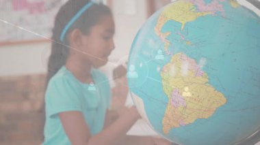 Sınıfta dönen kız notlar yazarken, simgeleri birleştirirken ve ülkeleri birbirine bağlarken. Eğitim, öğrenme, işbirliği, bağlantı, keşif, keşif, yenilik