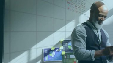 Bir işadamı ofiste cep telefonu kullanıyor. Veriler telefonun ekranında görüntülenir.