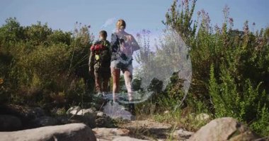 Sırt çantalarını sırtında taşıyan iki yürüyüşçü kadın tırmanana kadar dönüşümlü seyahat küresinin altından tırmanıyor. Macera, keşif, vahşi doğa, doğa, fitness, takım çalışması, keşif