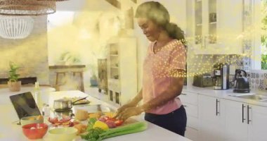 Ev aşçısı şef bıçağına uzanıyor. Sebzeleri laptopla doğruyor ve yemek tarifi için altın parıldıyor. Aşçılık, yaşam tarzı, minimalist, yerli, canlı, sağlıklı, odaklanma