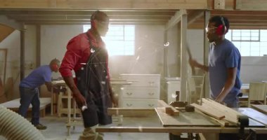 Eğitmen, eğitici, tahta testereyle tahta keserek tahta kesiyor, tozu dumana katıyor. Elektrikli aletler, işçilik, özel ders, endüstriyel, eğitim, işbirliği, kırsal