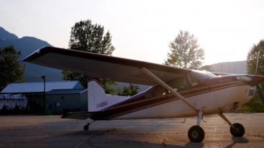 Açık gökyüzüne ve dağlara parketmiş çift kanatlı uçağın animasyonu. Değiştirilmemiş, hava aracı, ulaşım konsepti.