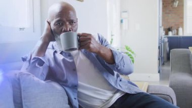 Afrika kökenli Amerikalı yaşlı bir adamın elinde bardak ve içki tutması üzerine ışık izlerinin animasyonu. Işık, hareket ve boş zaman konsepti dijital olarak oluşturulmuş video.