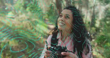 Fotoğrafçı tepe örtüsüne doğru bakıyor, DSLR 'yi yakalıyor, odaklanıyor ve fotoğraf için ormanı çekiyor. Doğa, yaban, açık hava, manzara, keşif, macera, bitki örtüsü.