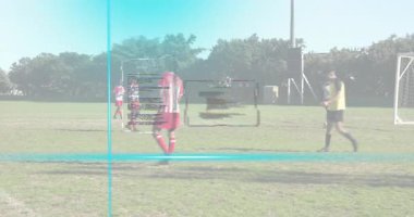 Saldırgan, kaleci HUD 'un altında atlarken topa vuruyor ve kaleye doğru ilerliyor. Futbol, spor, rekabet, atletizm, takım çalışması, açık hava, stratejik