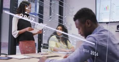 Sözcü kağıdı inceliyor ve teknik toplantı için devre veri aktifleştiriyor. İşbirliği, yenilik, analitik, veri görselleştirme, modern ofis, takım çalışması, profesyonel büyüme