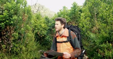 Yetişkin erkek yürüyüşçü harita üzerinde çalışıyor, mavi ya da sarı teknik navigasyon görselleştirmesini başlatıyor. Macera, keşif, vahşi doğa, teknoloji, yenilik, keşif, açık hava