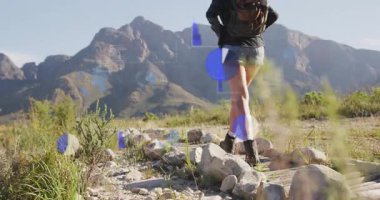 Bir kadın tahta üzerine basıyor yüzen teknik grafikleri aktifleştiriyor iz verilerini analiz ediyor ve erkek katılıyor. Macera, keşif, açık hava, engebeli, analiz, navigasyon, takım çalışması