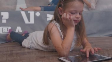 Animation of math symbols and lights over caucasian girl using tablet. Childhood and spending time with technology concept digitally generated video.