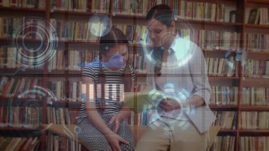 Mid-adult woman turning book page sparking holographic charts guiding student learning in library. Education, mentorship, technology, innovation, literacy, collaboration, curiosity