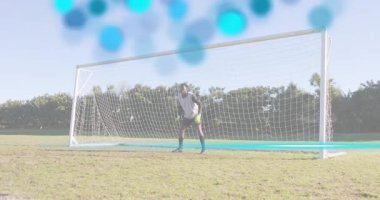 Keeper sensing blue circles signaling drill lunging to right post grabbing soccer ball for practice. Athlete, training, action, sport, fitness, outdoor, determination