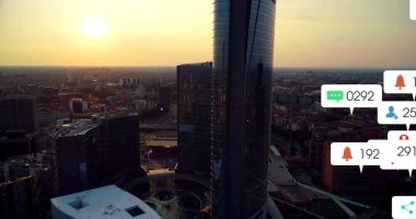Banyo camlı gökdelenler şehir merkezinin üzerinde altın günbatımı ışığını emerek, uyarı simgeleriyle birlikte. Gökdelenler, şehir manzarası, hava manzarası, modern mimari, şehir silueti, günbatımı aydınlatması, dijital uyarılar