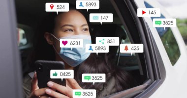 Ceket ve cerrahi maske takan röntgenci kadın park halindeki arabada akıllı telefon kullanıyor, bilgilendirme simgeleri kullanıyor. Teknoloji, iletişim, sosyal medya, mobil, kentsel yaşam tarzı, bağlantı