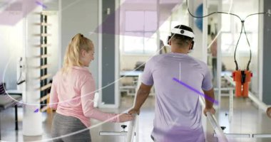 patient stepping between parallel bars in rehab gym therapist supporting wrist and stabilizing gait. Rehabilitation, physiotherapy, mobility, therapy, assistance, recovery, exercise