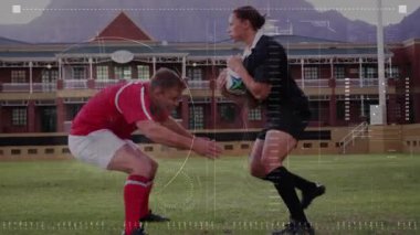 Savunma oyuncusu sahada siyah top taşıyıcısını tutuyor. Gözlemci spor izlerken oyunu durduruyor. Sporcular, yarışma, açık hava, aksiyon, spor, takım çalışması, yoğunluk