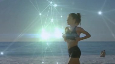 Çerçeveye giren kadın koşucu kıyı şeridi boyunca koşarken sağlık teknisyenleri okyanus üzerinde titreşim yayıyor. Atletizm, canlılık, yenilik, teknoloji, açık hava, dinginlik, ilham