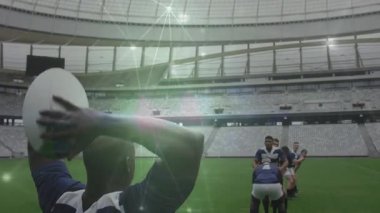 İki numaralı formayı giyen atıcı, ragbi oyuncularına el altından top atıyor. Atlayan atlamacı topu yakalıyor. Atletik, takım çalışması, rekabetçi, aksiyon, sportmenlik, stadyum, zafer