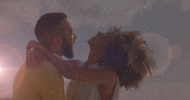 Güneşli gökyüzünün altında, ışık ve yıldız lekeleriyle gülümseyen ve eğilen çift. Romantizm, samimiyet, doğa, dinginlik, neşe, bağlantı, açık hava