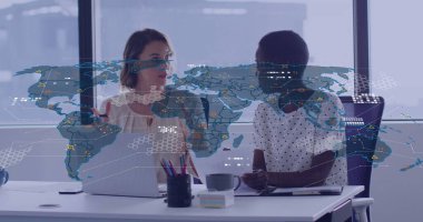 İş kıyafetleri giymiş iki kadının çalışma masasında dizüstü bilgisayar ve tabletle proje verilerini analiz etmesi. İşbirliği, takım çalışması, profesyonellik, veri analizi, modernlik, dijital araçlar, üretkenlik