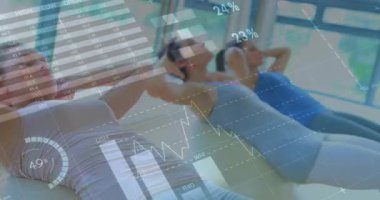 Kadınlar ellerini başlarının arkasına koyuyor ve mekik çekerken spor istatistiklerini aktifleştiriyor. Grup egzersizi, dijital analiz, sağlık, dayanıklılık eğitimi, sağlıklı yaşam tarzı, modern spor salonu, açık hava ışığı.