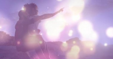 Afrika kökenli Amerikalı bir çiftin deniz kenarındaki kayalıklarda parlayan ışık noktalarının animasyonu. Aşk ve ilişki kavramı