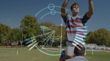 Top kavisli, takım rugby antrenmanı için çömelmiş ve zıplayıcı kaldırıyor, dönen HUD ortasında topu yakalıyor. Atletizm, takım çalışması, açık hava, spor, rekabet, antrenman, hareket