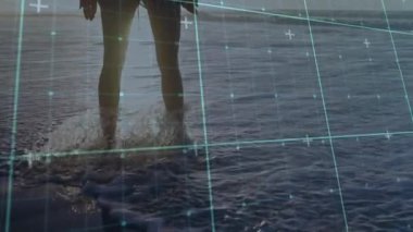 Plajdaki kadın sörf yapıyor ve canlı vücut taraması için teknolojik şebekeyi çalıştırıyor. Deniz manzarası, dinginlik, teknoloji, fütürizm, manzara, siluet, yenilik