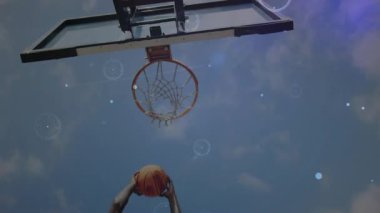 Erkek sporcu yükselen top, çemberin etrafında yanıp sönen ışık fişekleriyle sayı yapmak için çembere çarpıyor. Eylem, atletizm, spor, dijital efektler, açık hava, motivasyon, dinamik