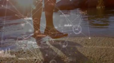 Ayak parmaklarını kuma bastıran ve suya basan adam dalgalanmalara ve hareketli teknoloji düğümlerini aktifleştiriyor. Deniz kıyısı, kıyı şeridi, su, dalgalar, teknoloji, bağlantı, analiz
