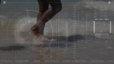 Sahilde yürüyen çift sıçramalara, dalgalanmalara yol açarken teknoloji HUD grafikleri verileri analiz ediyor. Sahil, sahil, su, dalgalar, sıçrama, yalınayak, doğa.