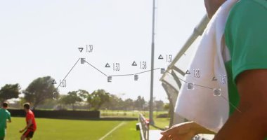 Personel su şişesine uzanıyor ve futbol oyuncuları topa karşı oynarken susuz kalıyor. Atletizm, hidrasyon, fitness, açık hava, takım çalışması, spor, yarışma