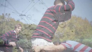 Rugby oyuncusu hücum ediyor, top tutarak topa vuruyor, sert pençe vuruyor ve topu güvenli bir yere götürüyor. Atletizm, spor, takım çalışması, açık hava, rekabet, canlı, dinamik