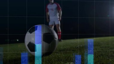 Erkek sporcu gece futbolunda kilo değiştiriyor, yükselen mavi çizelgeler ve dünya haritası veri rehberliği tekmeleri. Sporcu, spor analizi, dijital arayüz, performans takibi, açık hava stadyumu, hareket dinamiği, ileri teknoloji
