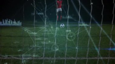 Serbest vuruş için koşan erkek futbolcu analitik etkinleştirici topun yörüngesini belirliyor. Atletik, spor, rekabet, dijital, teknolojik, performans, açık hava