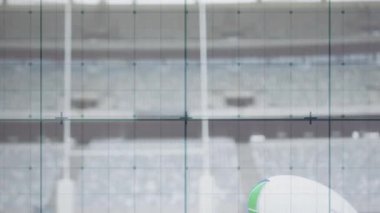 Rugby topunun ucu çerçeveye giriyor. Atış yapmak için şut şalteri altında döner gibi dönüyor. Spor malzemeleri, açık hava, minimalist, hassasiyet, rekabet, stadyum, atletizm