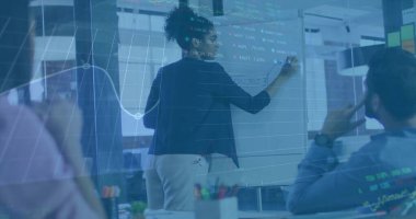 Koyu renk spor ceket giyen bir kadın konferans odasındaki beyaz tahtaya işaret koyuyor. Üzerinde de işaret ve çizelge var. İşbirliği, takım çalışması, iş, dijital, veri, analiz, strateji