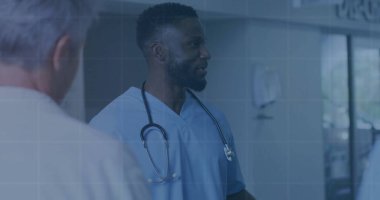 Hastane koridorunda mavi önlük ve beyaz önlüklü doktorla stetoskop kullanan bir hemşire. Tıbbi, takım çalışması, profesyonel, sağlık, klinik, işbirliği, kurumsal