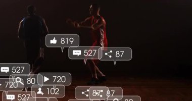 Kırmızı formalı oyuncu spor eğitiminde smaç basıyor ve medyanın canlandırılmış simgelerinin çemberin yakınında yükselmesine neden oluyor. Atletizm, takım çalışması, enerjik, canlı, motivasyon, rekabet, kentsel